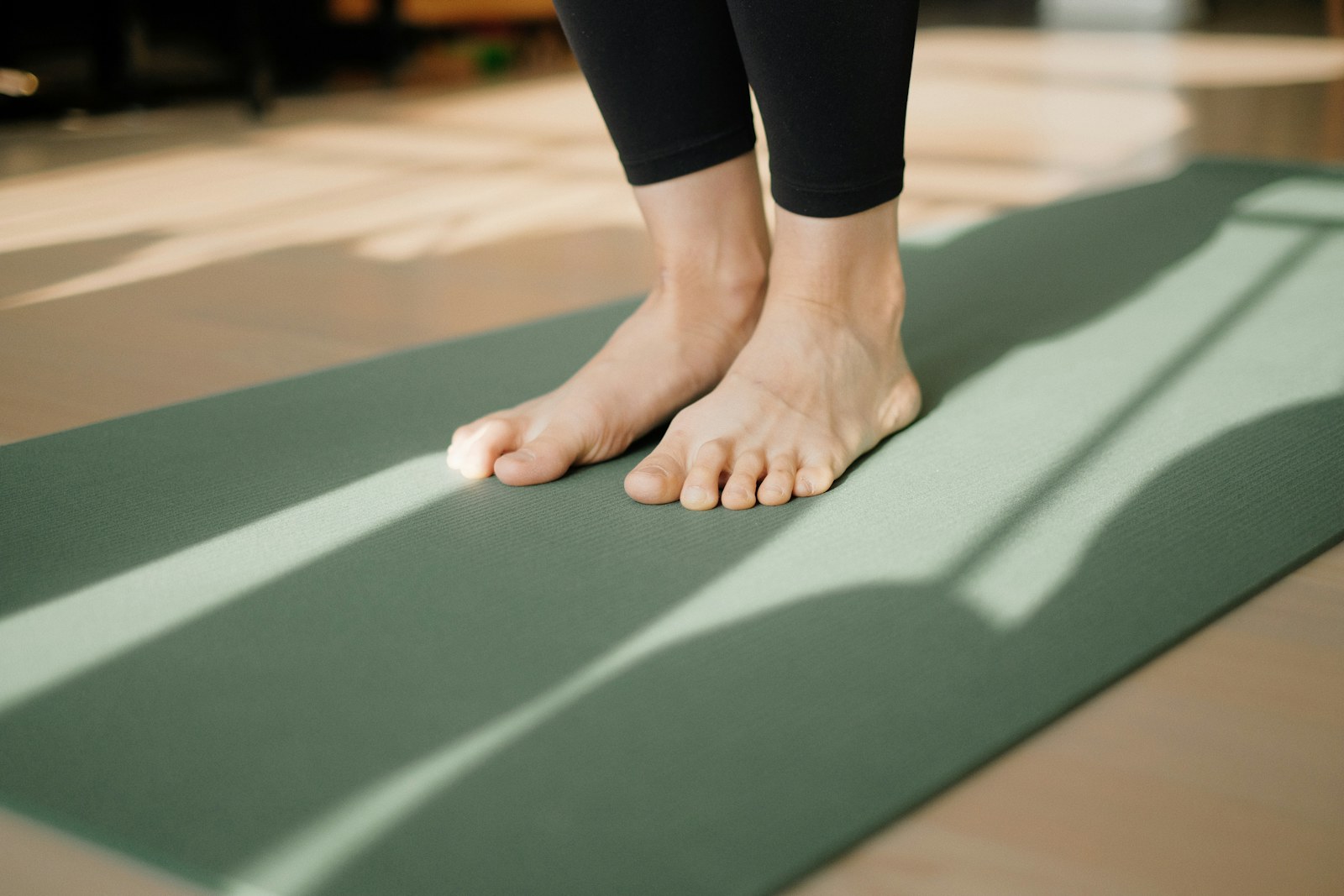 Person standing barefoot on an exercise mat